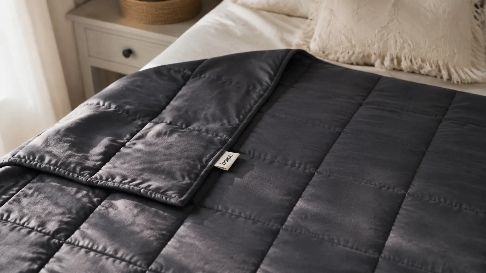 Woman sleeping soundly under a weighted blanket in a dimly lit bedroom